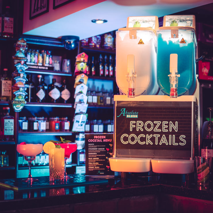 Absolute Frozen Cocktail Machine - lifestyle image at a bar with cocktails at the side